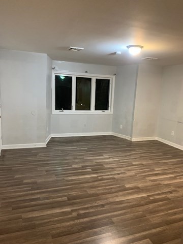 174 Jencks Street, Unit 3 Fall River, MA 02723 - Photo 5 of 5 a view of an empty room with wooden floor and a window