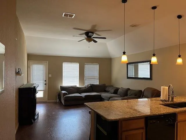 a living room with furniture a ceiling fan and a wooden floor