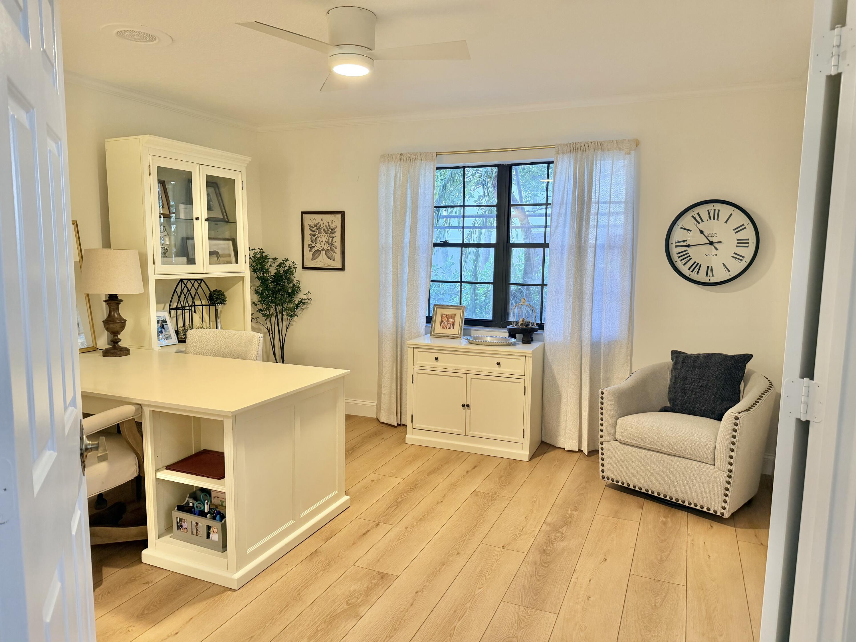 22728 Caravelle Circle Boca Raton, FL 33433 - Photo 34 of 39 a living room with furniture a clock on wall and a window