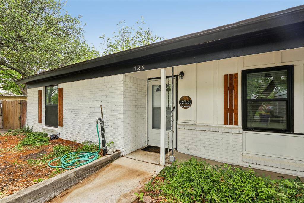 426 West Lake Street Krum, TX 76249 - Photo 1 of 16 a front view of a house with a garden
