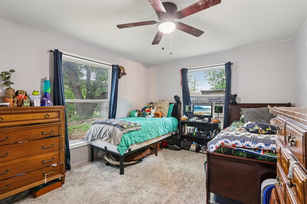 426 West Lake Street Krum, TX 76249 - Photo 12 of 16 a bedroom with a bed and a chandelier