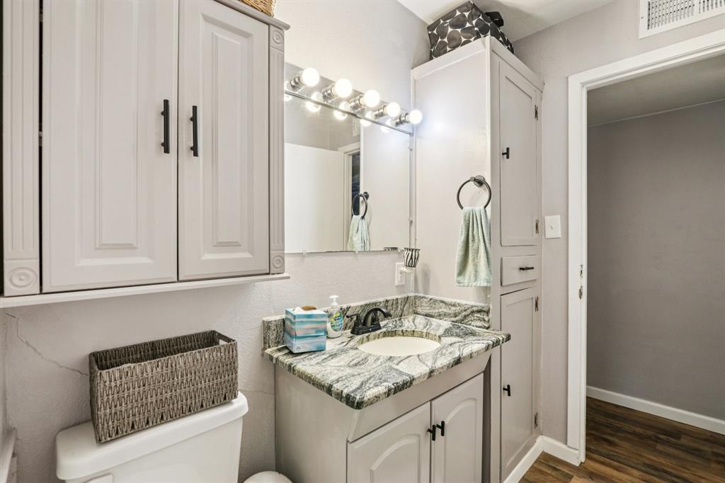 426 West Lake Street Krum, TX 76249 - Photo 13 of 16 a bathroom with a granite countertop sink and a mirror