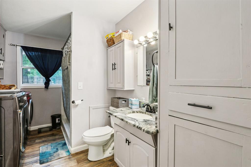 426 West Lake Street Krum, TX 76249 - Photo 14 of 16 a bathroom with a granite countertop toilet sink and mirror