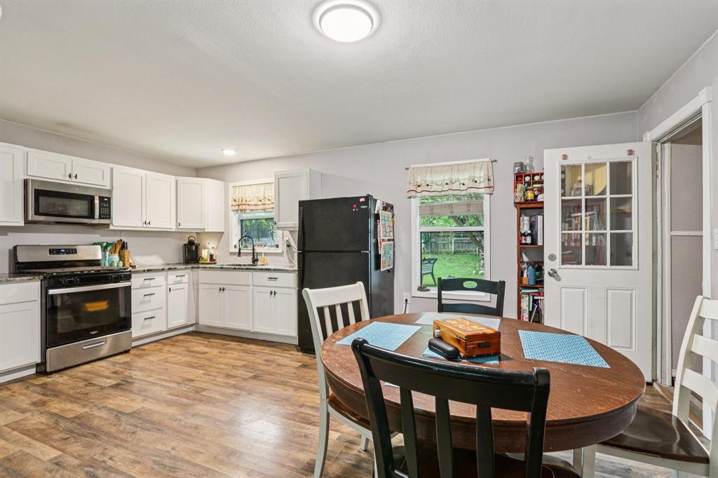 426 West Lake Street Krum, TX 76249 - Photo 5 of 16 a kitchen with a stove a sink a dining table and chairs