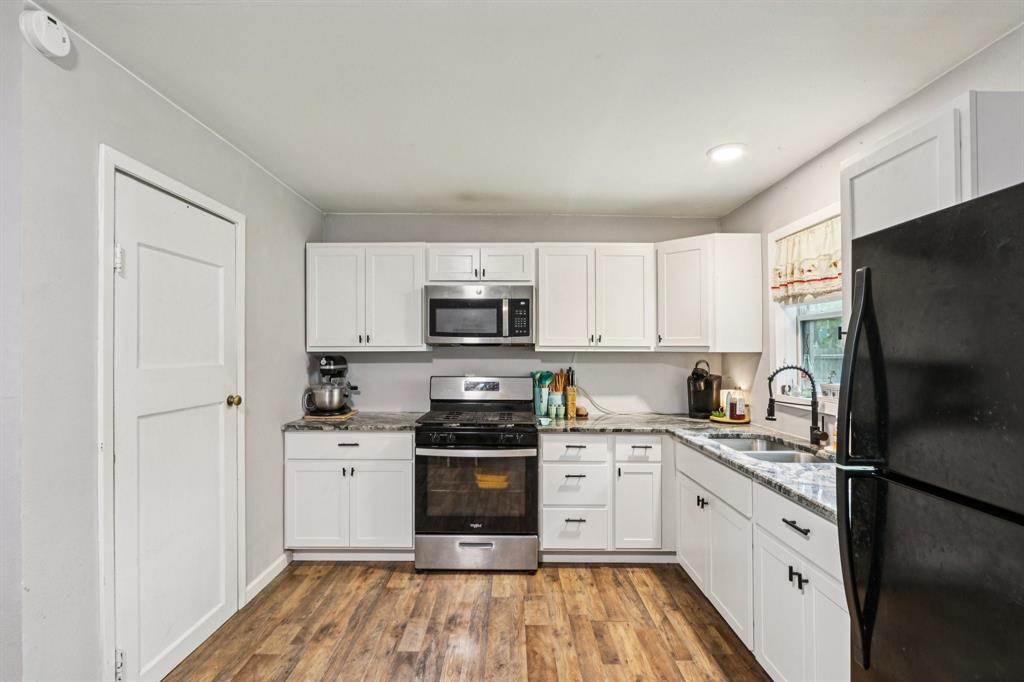 426 West Lake Street Krum, TX 76249 - Photo 6 of 16 a kitchen with stainless steel appliances granite countertop a stove a sink and a refrigerator