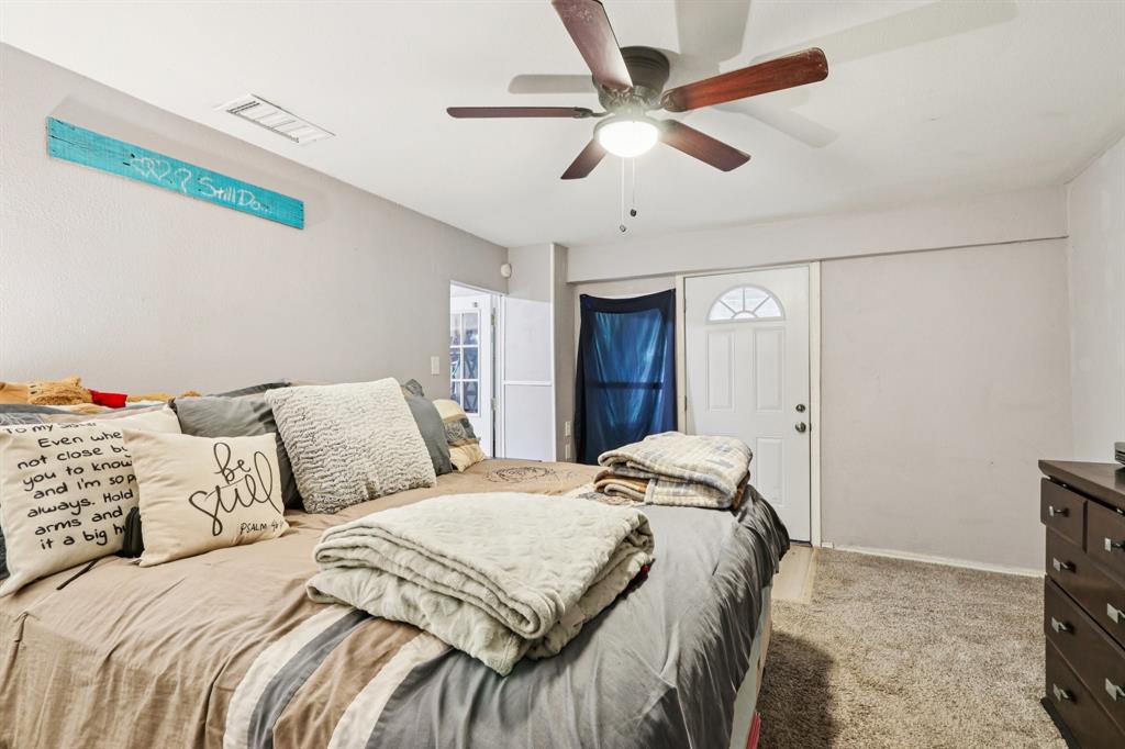 426 West Lake Street Krum, TX 76249 - Photo 7 of 16 a bedroom with a large bed and a ceiling fan