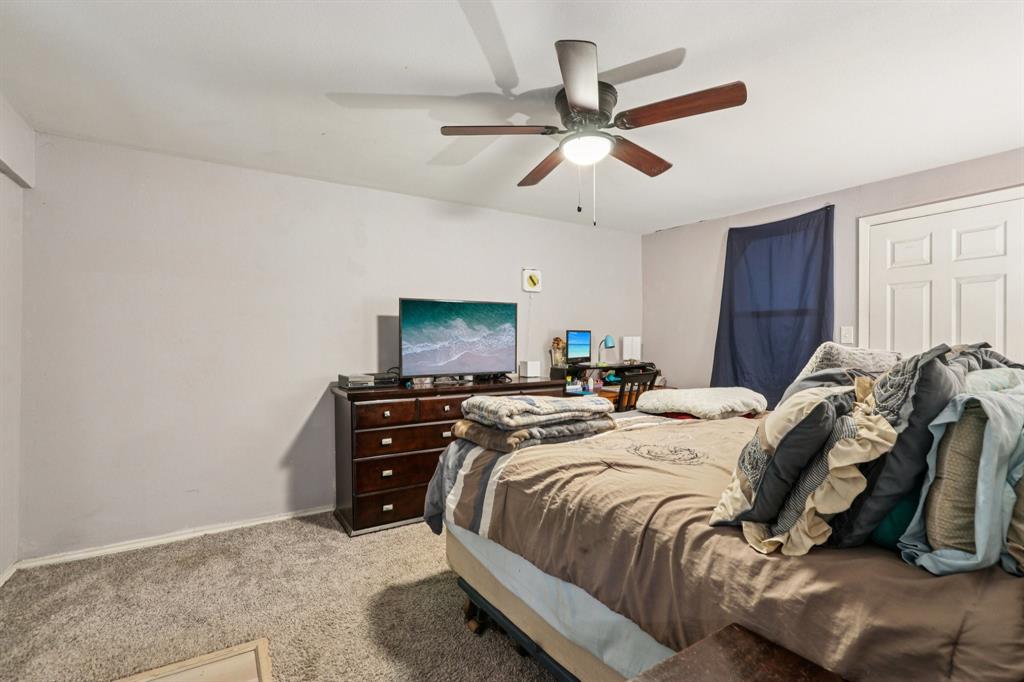 426 West Lake Street Krum, TX 76249 - Photo 9 of 16 a bed room with a bed and a television