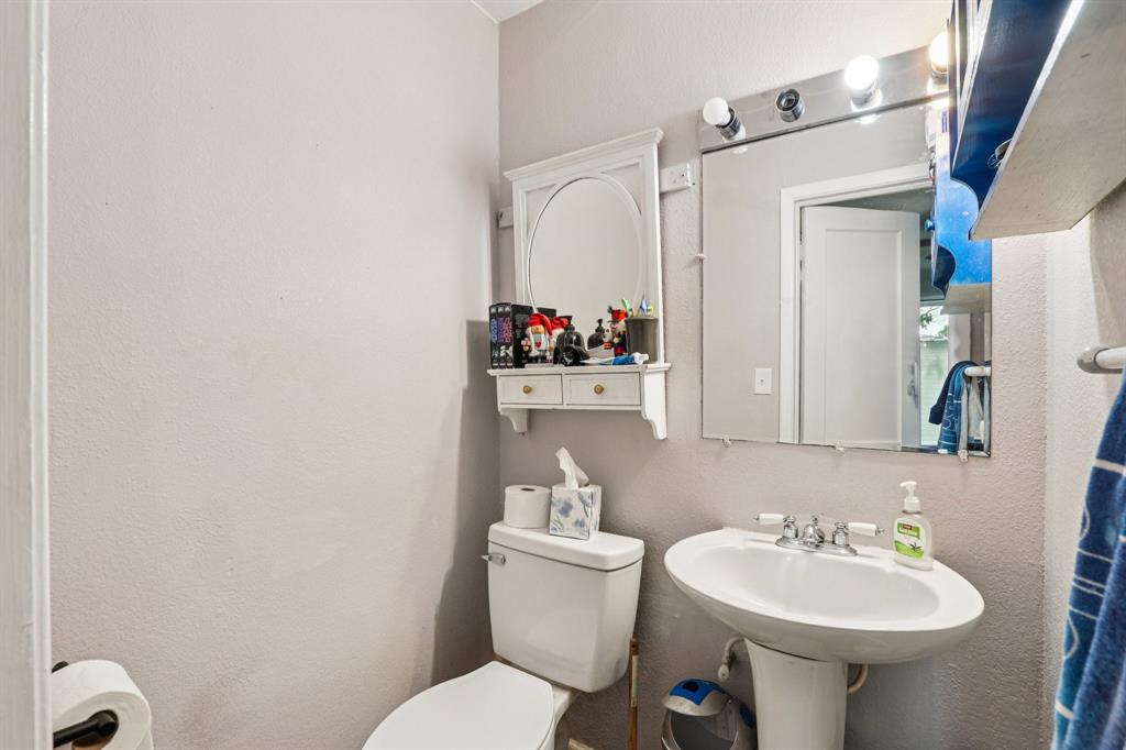 426 West Lake Street Krum, TX 76249 - Photo 10 of 16 a bathroom with a sink mirror toilet and vanity