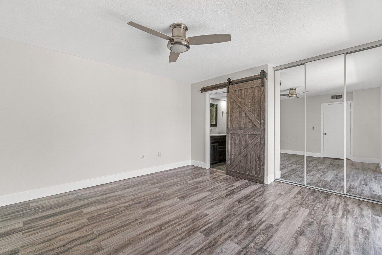 2929 Southwest 22nd Circle, Unit 32B Delray Beach, FL 33445 - Photo 15 of 27 wooden floor in an empty room with a window