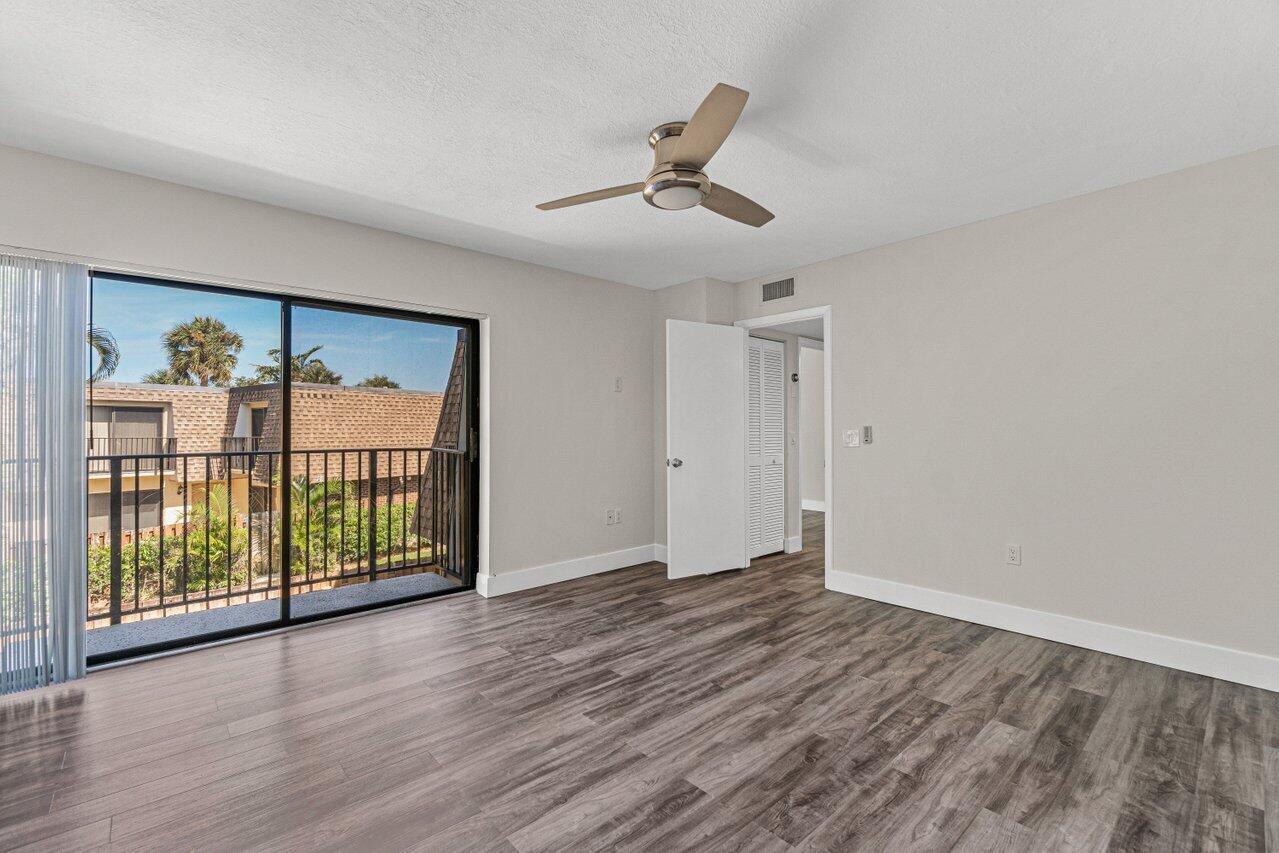 2929 Southwest 22nd Circle, Unit 32B Delray Beach, FL 33445 - Photo 16 of 27 a view of an empty room with wooden floor and a window