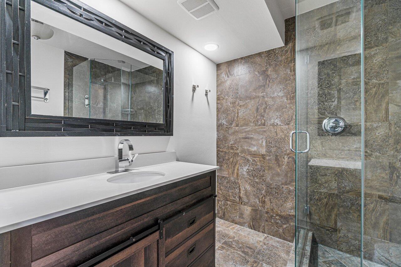 2929 Southwest 22nd Circle, Unit 32B Delray Beach, FL 33445 - Photo 18 of 27 a bathroom with a sink a mirror and shower