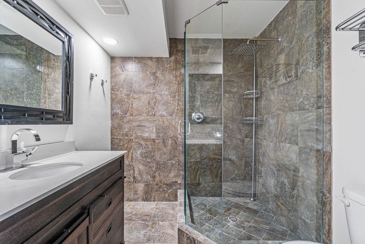 2929 Southwest 22nd Circle, Unit 32B Delray Beach, FL 33445 - Photo 19 of 27 a bathroom with a shower sink and mirror