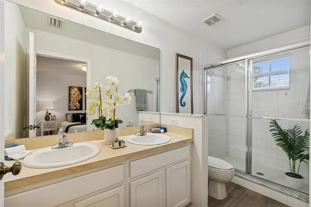 a bathroom with a double vanity sink toilet and shower