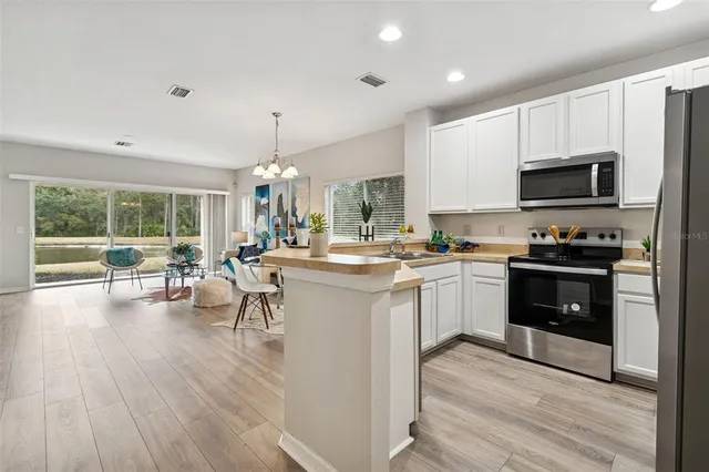 a kitchen with a sink cabinets and wooden floor
