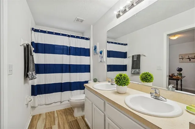 a bathroom with a sink and mirror with toilet