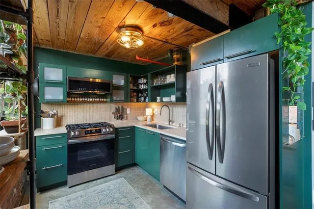 a kitchen with stainless steel appliances granite countertop a refrigerator a stove and a sink with wooden floor