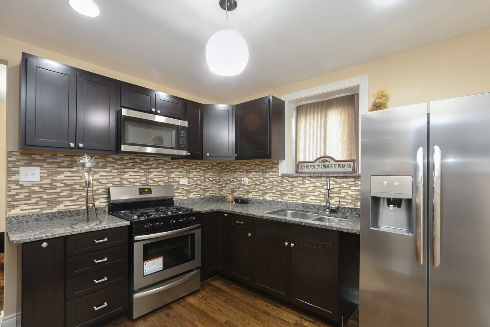 10217 South Prairie Avenue Chicago, IL 60628 - Photo 4 of 23 a kitchen with stainless steel appliances granite countertop a sink and stove top oven