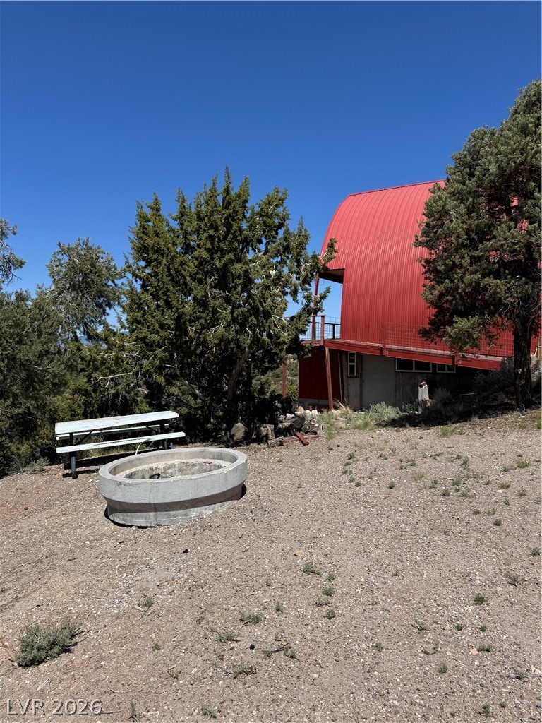 20996 Pinion Pine Road Pioche, NV 89043 - Photo 16 of 19 This unique structure features a vibrant red roof against a clear blue sky, surrounded by natural landscaping.