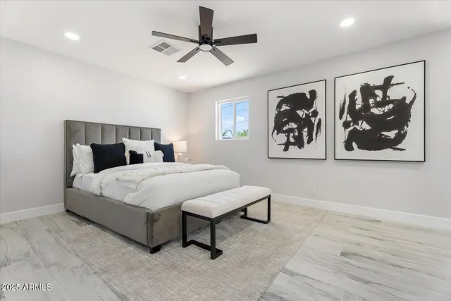 a bedroom with a large bed and a painting on the wall