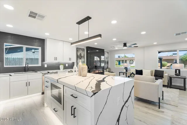 a large white kitchen with a sink and cabinets
