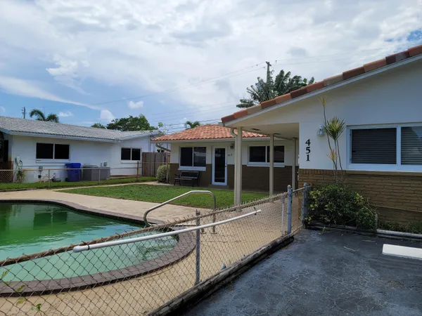 a view of house with swimming pool and outdoor seating