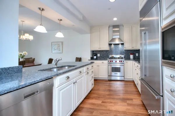 a large kitchen with stainless steel appliances kitchen island granite countertop a sink and cabinets