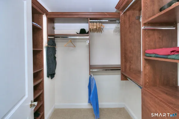 a view of walk in closet with clothes and shoes