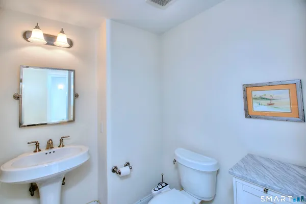 a bathroom with a toilet a sink and mirror