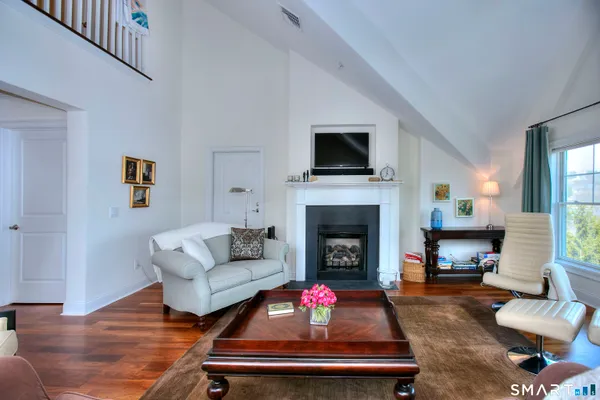 a living room with furniture a flat screen tv and a fireplace