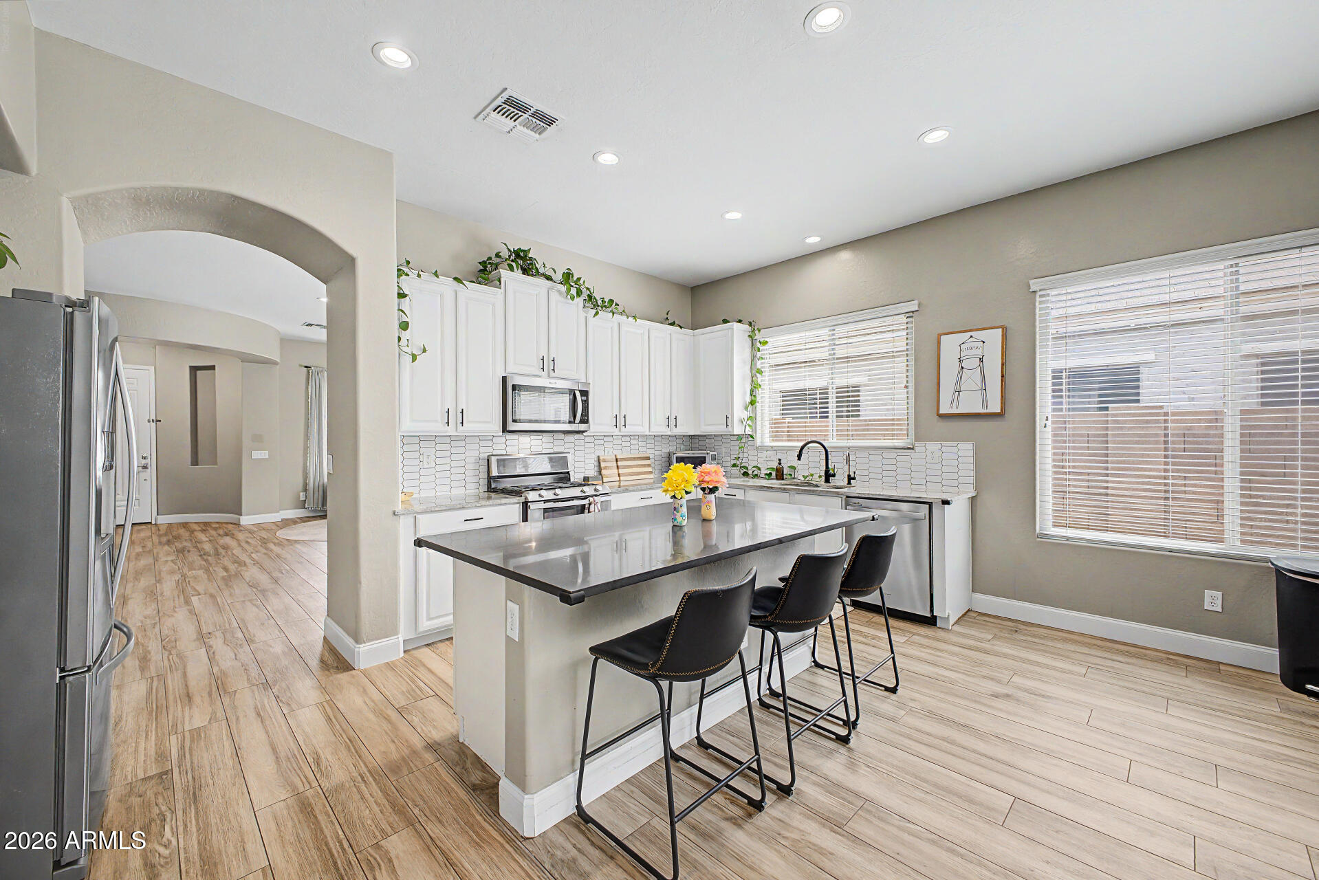 4272 East Buckboard Road Gilbert, AZ 85297 - Photo 16 of 37 a kitchen with stainless steel appliances a dining table chairs and wooden floor