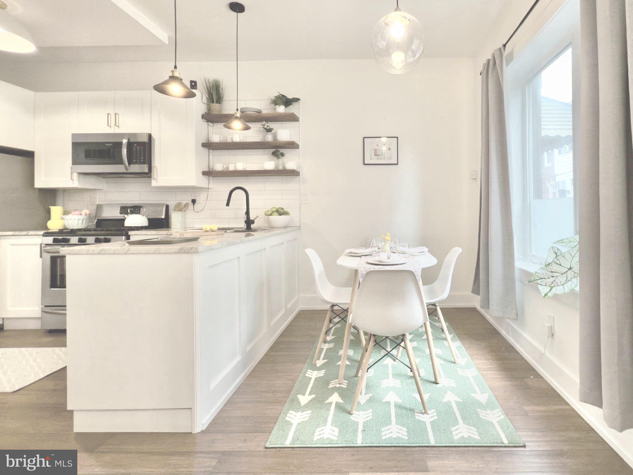 637 Cross Street Philadelphia, PA 19147 - Photo 7 of 28 a kitchen with stainless steel appliances granite countertop a dining table chairs wooden floors and white walls