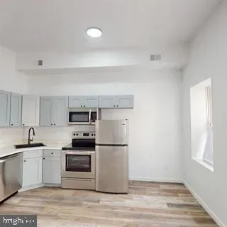 a kitchen with granite countertop a refrigerator and a sink