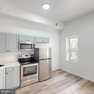 a kitchen with a refrigerator stove and microwave