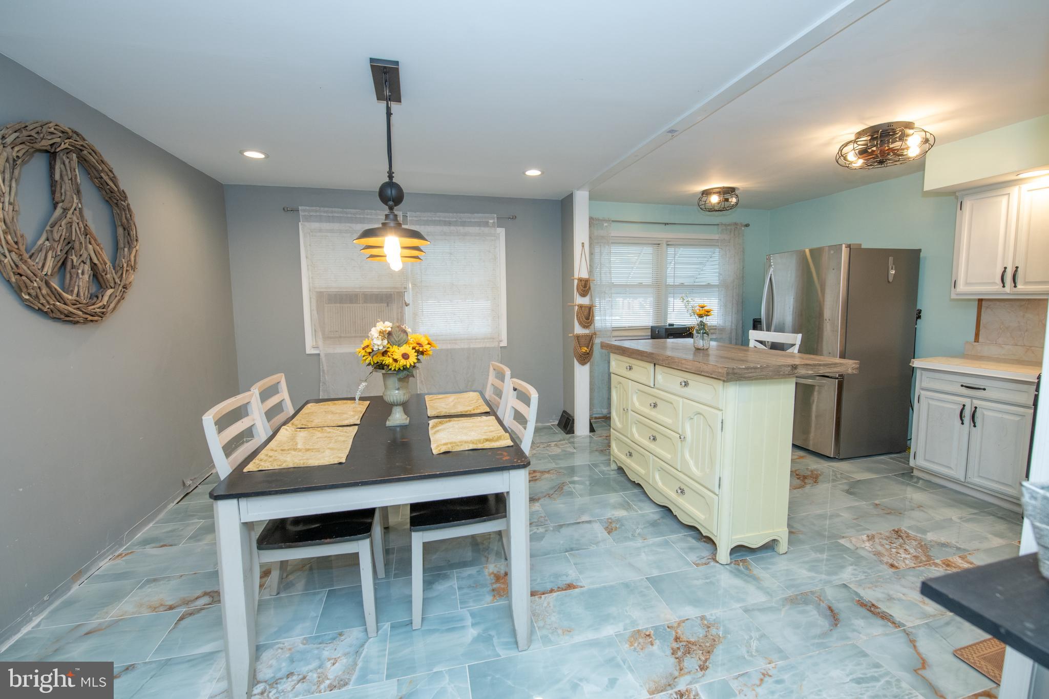 12506 Chilton Road Philadelphia, PA 19154 - Photo 21 of 55 a kitchen with a refrigerator a sink dishwasher a dining table and chairs with wooden floor