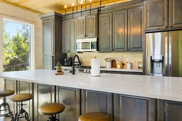 a kitchen with granite countertop a table chairs stove and cabinets