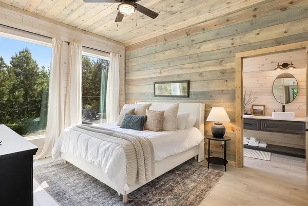 a bedroom with a bed and a large window with outer view