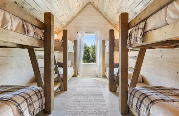 a view of a bedroom with wooden floor and furniture