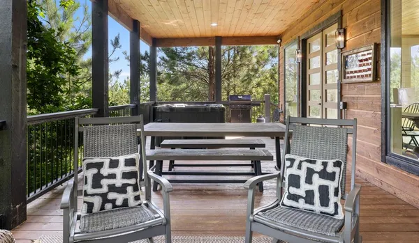a view of a patio with chairs and table with wooden floor