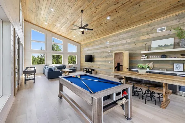 a living room with stainless steel appliances kitchen island granite countertop furniture and a flat screen tv