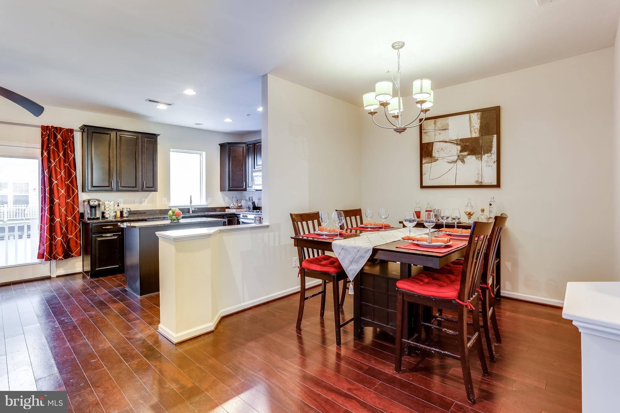 1109 Red Hawk Way Severn, MD 21144 - Photo 10 of 29 a living room with dining table wooden floor and kitchen view