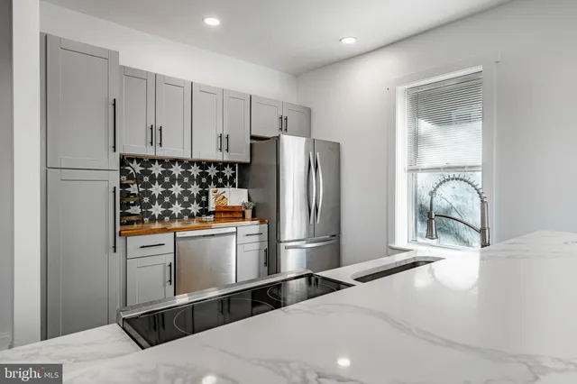 a kitchen with stainless steel appliances a refrigerator sink and cabinets