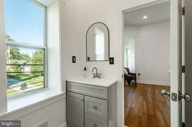 a bathroom with a sink a toilet and a large mirror