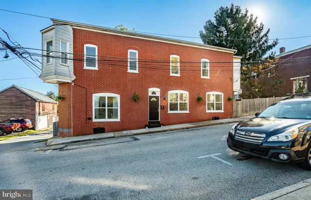 a couple of cars parked in front of a house