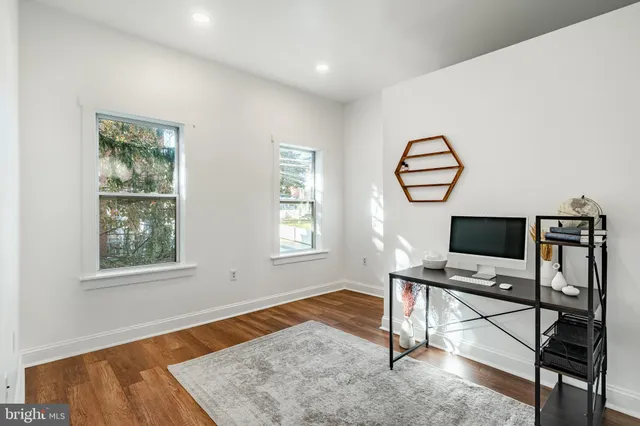 a view of a workspace with furniture and a window