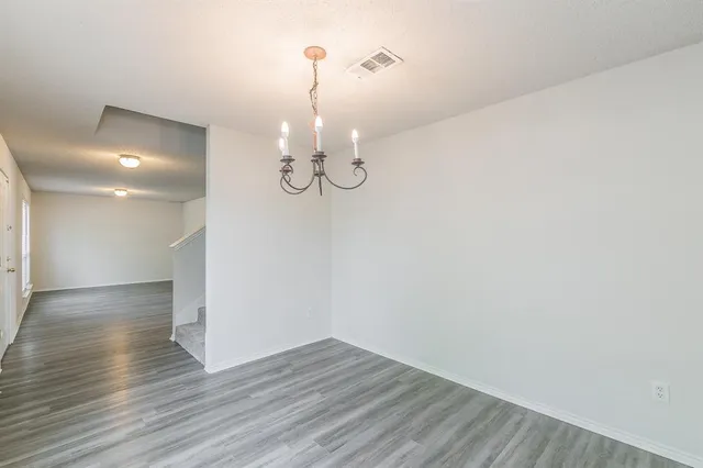 a view of a room with wooden floor and chandelier