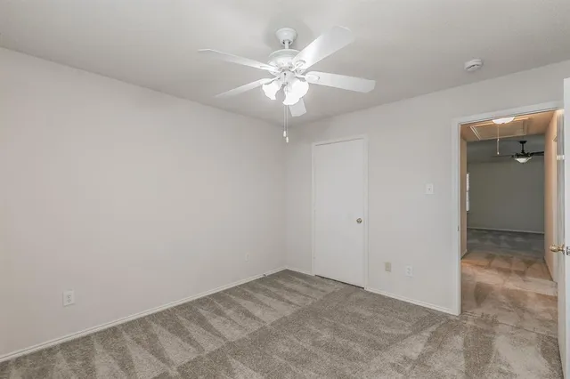 an empty room with a fan and a window
