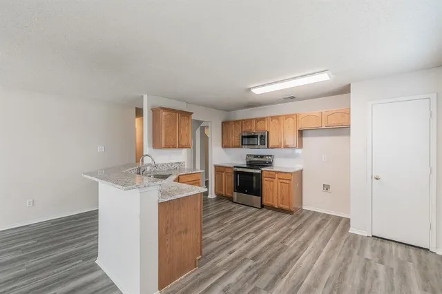 a kitchen with granite countertop a stove top oven and cabinets