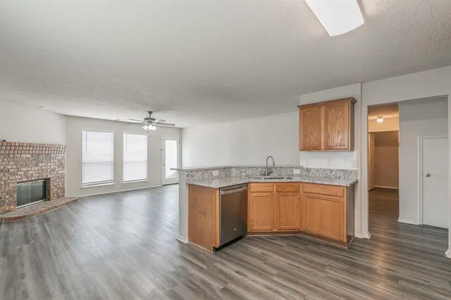 a kitchen with granite countertop a stove and wooden floor