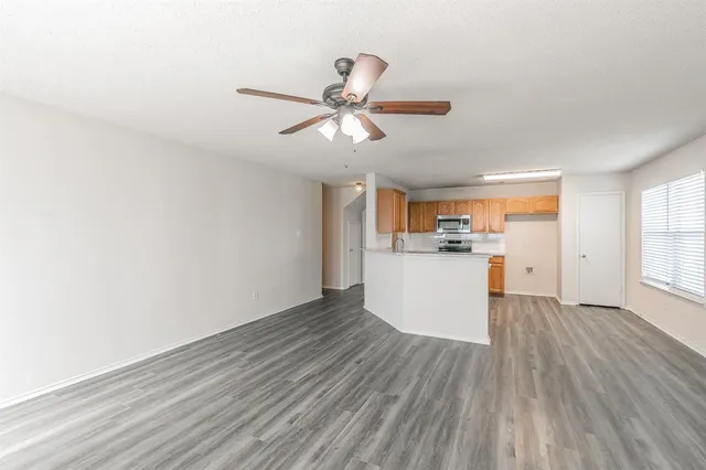a view of a kitchen with wooden floor and a ceiling fan