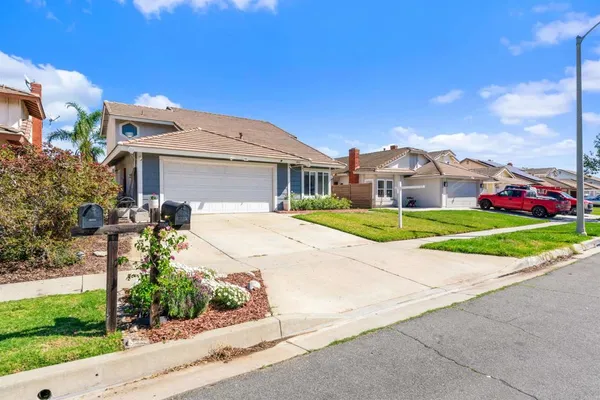 a front view of a house with a yard and potted plants